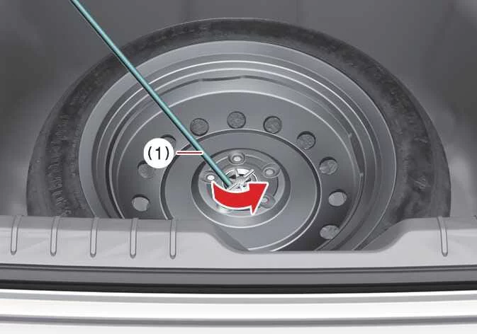 Using the jack handle to loosen the spare tire hold-down wing bolt in a Kia K4