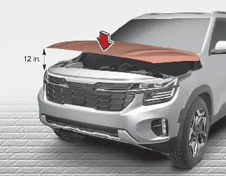 Kia Seltos hood being lowered and closed securely